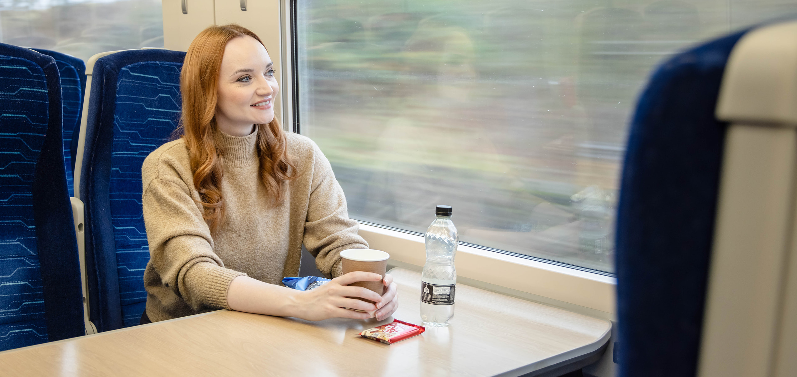 A passenger onboard Hull Trains with food and drink from the trolley